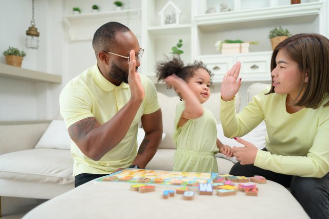 family and child playing games and winning together