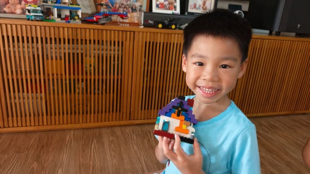 boy smiling with his lego creation