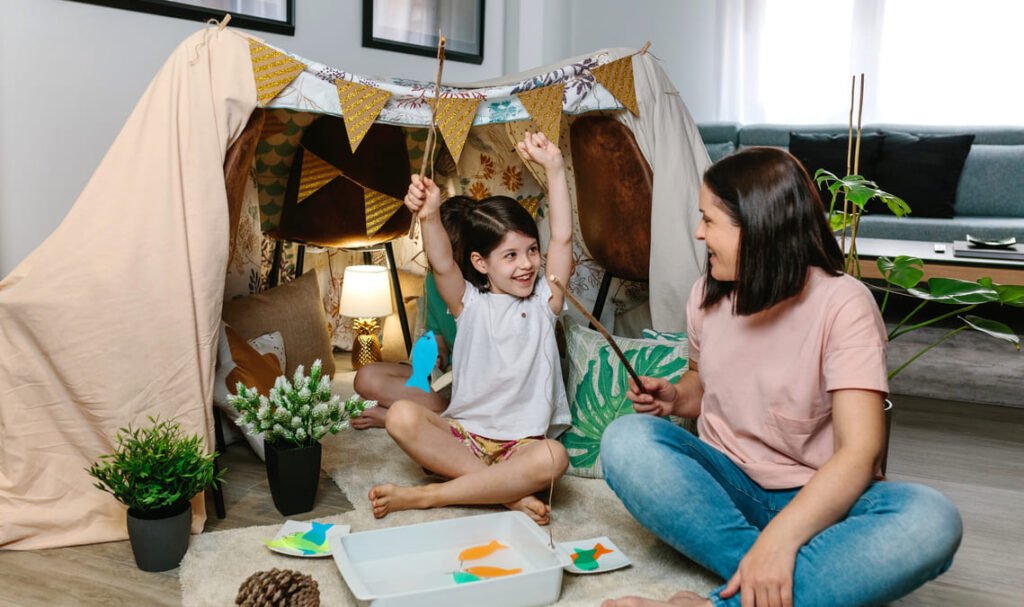 kids building a tent indoors on a rainy day screen free play at home