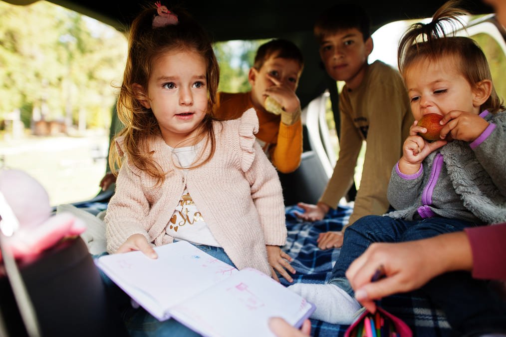 Kids playing games in car during a road trip