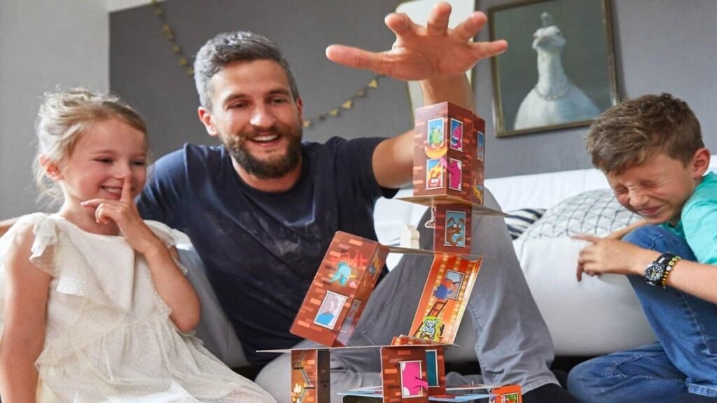 Family laughing and reacting as the Rhino Hero card tower topples during a game