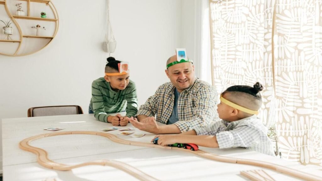 A father playing card games with his two young sons at home