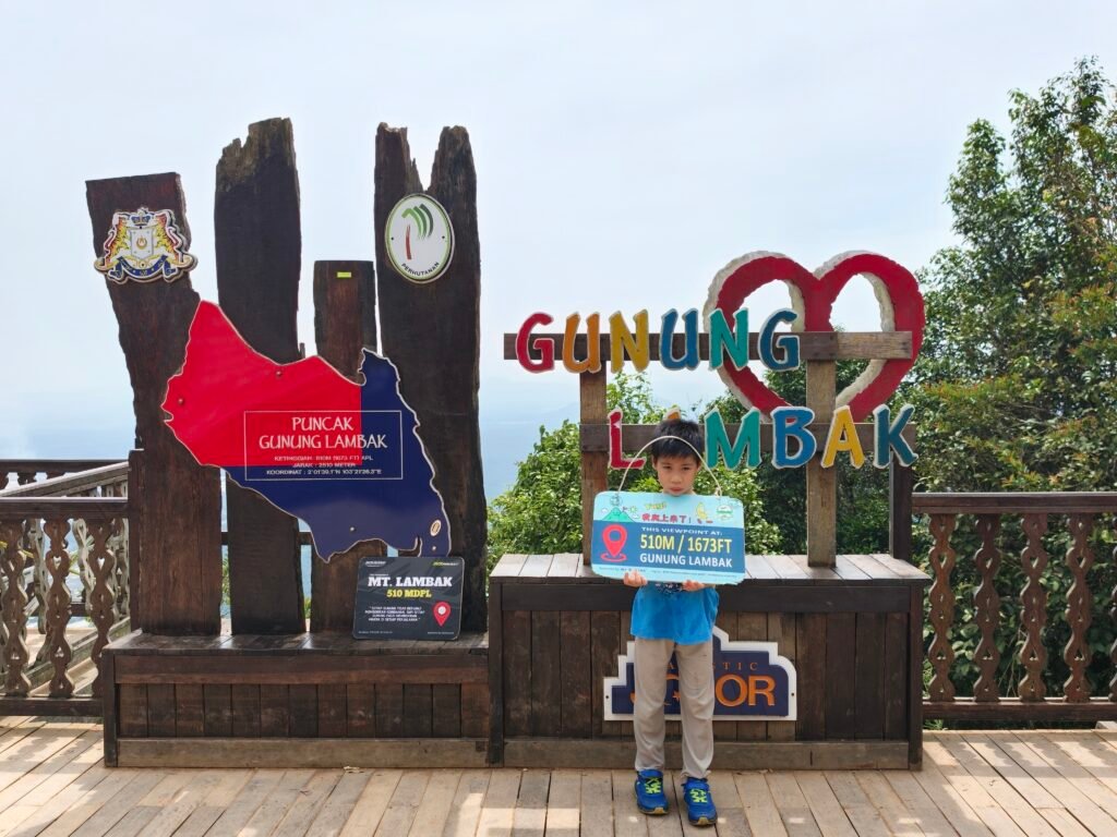 a photo of a young 8 year old boy at the summit of Gunung Lambak, who did not look too happy