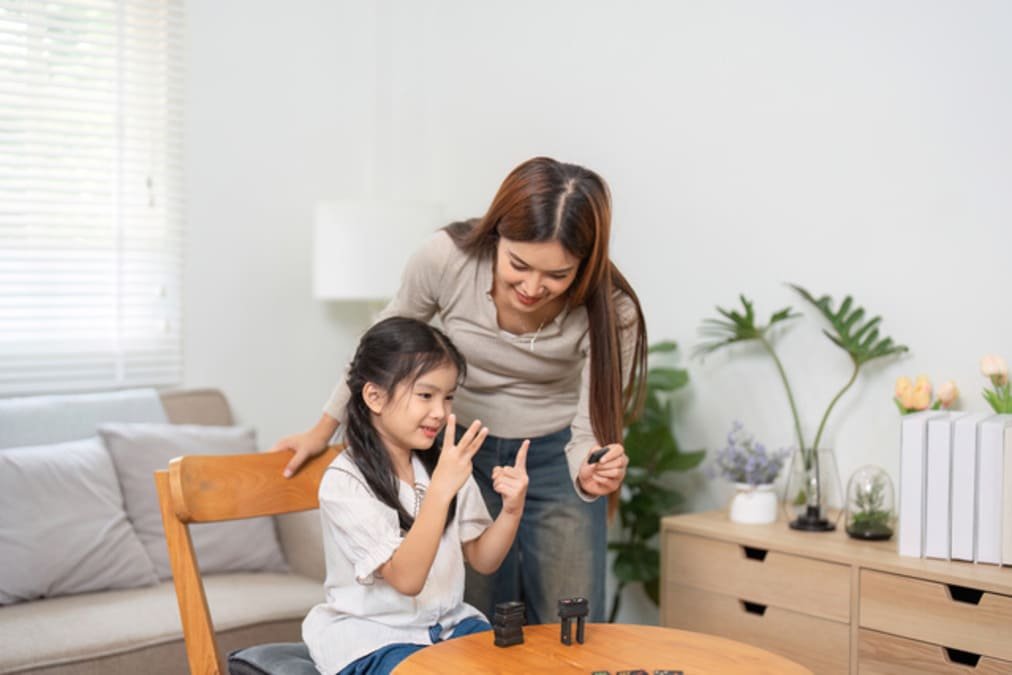 A parent and a kid setting up a new board game at a Table