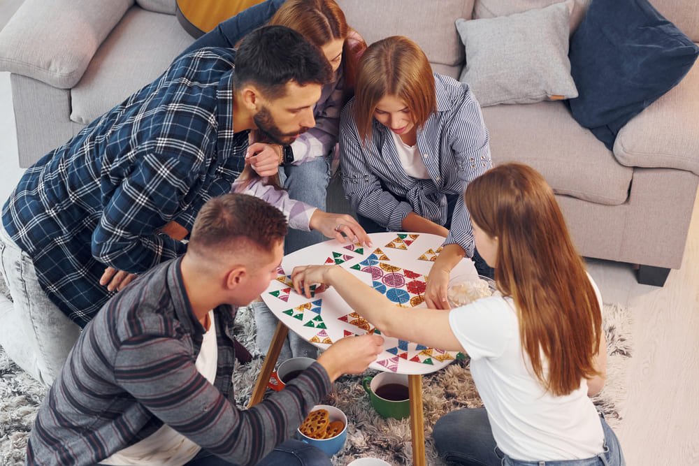 Children playing a board game together at a coffee table during the school holidays