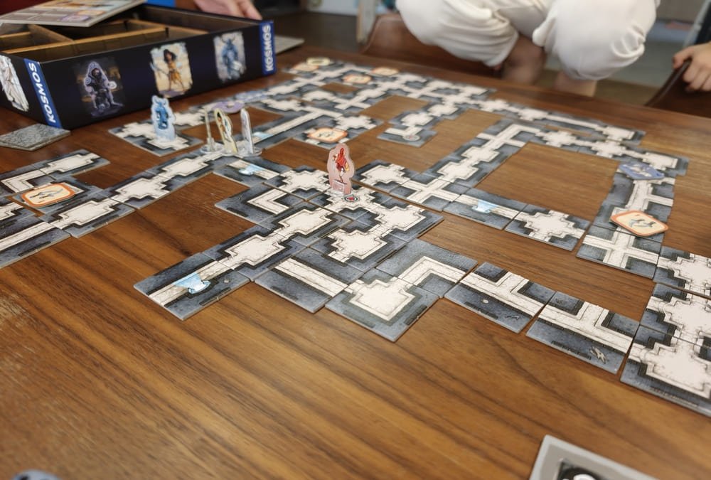 The dragon tile revealed at the end of a game of Karak, with several character standees gathered around it for the final battle